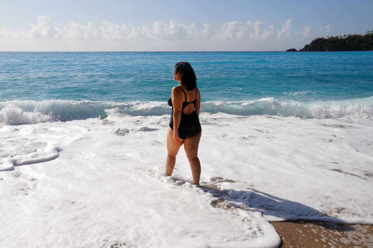 Black one-piece swimsuit offering confident coverage in a swimsuit guide for women with big thighs.