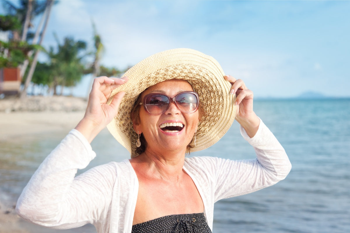 Woman enjoying the beach after finding bikinis for older women.